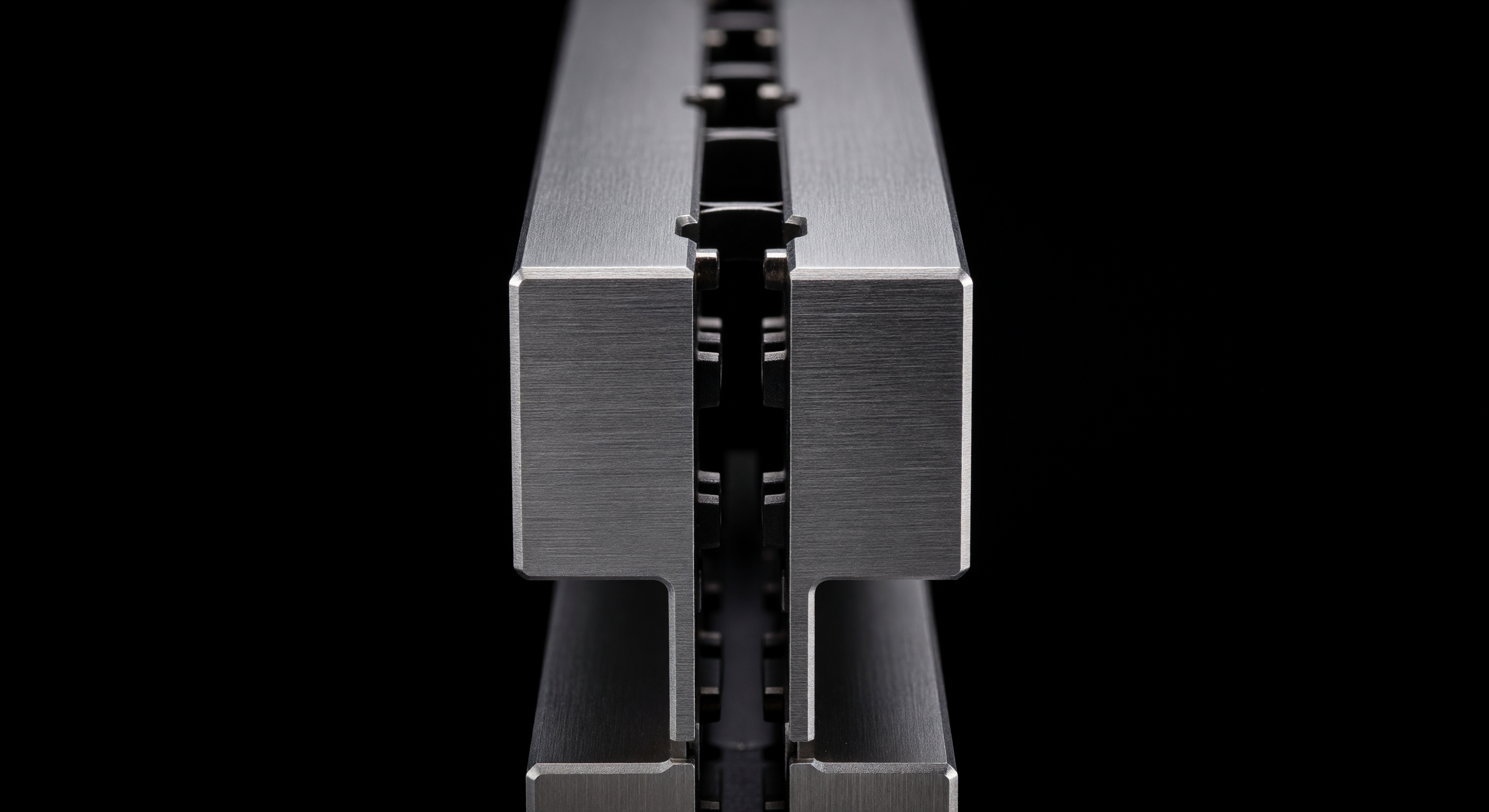 Extreme macro close-up of two identical, heavy steel server blades slotted perfectly next to each other.